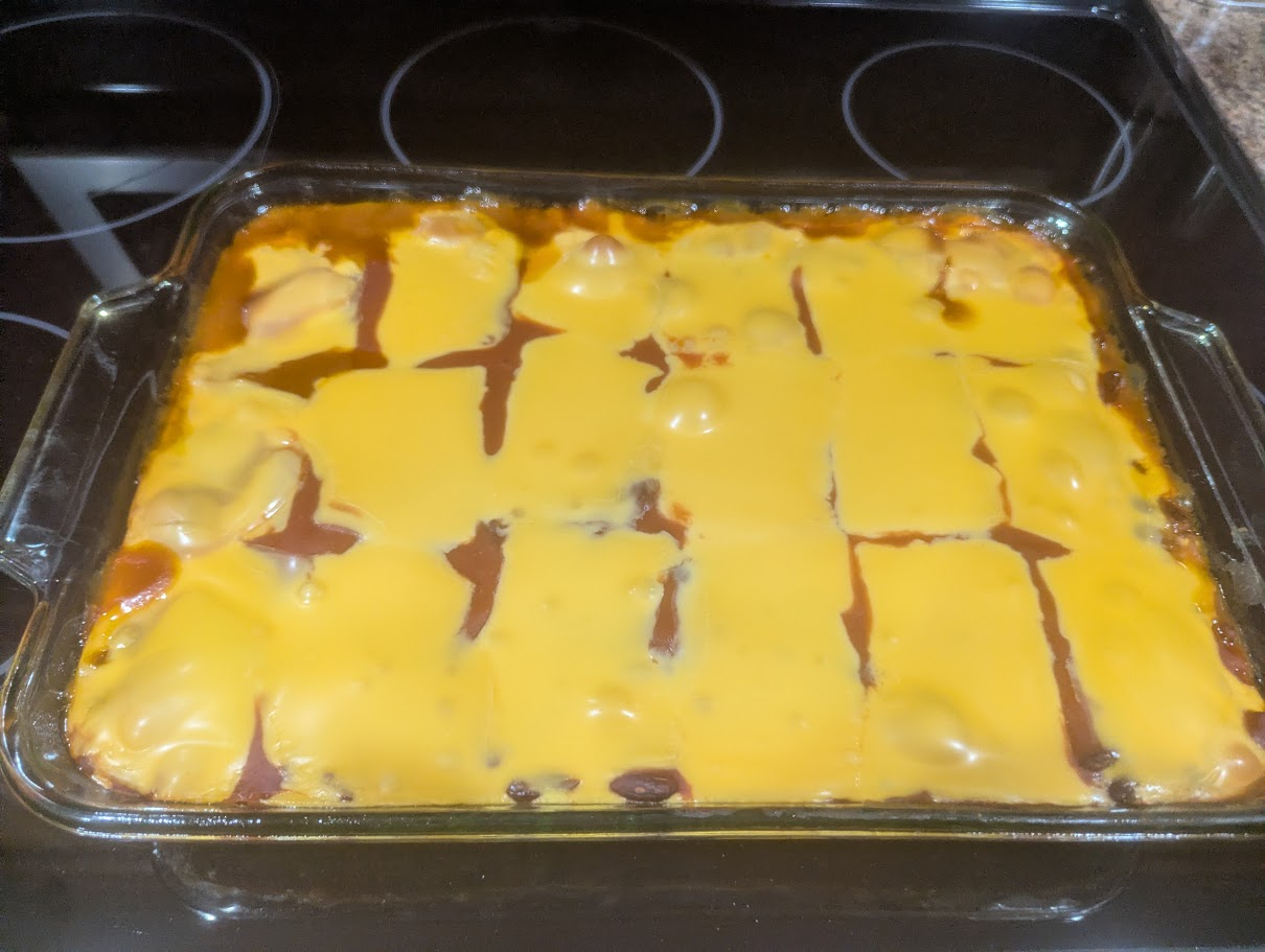 Shipwreck casserole baked in a glass dish with melted cheese on top