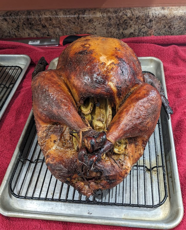 Finished smoked turkey resting on a rack